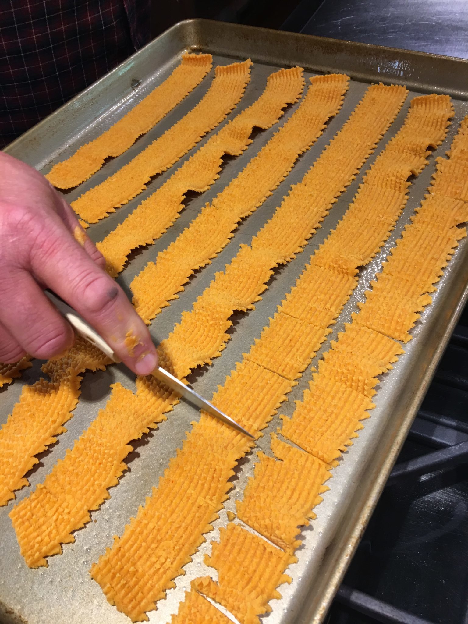 Cutting cheese crackers before putting in the oven