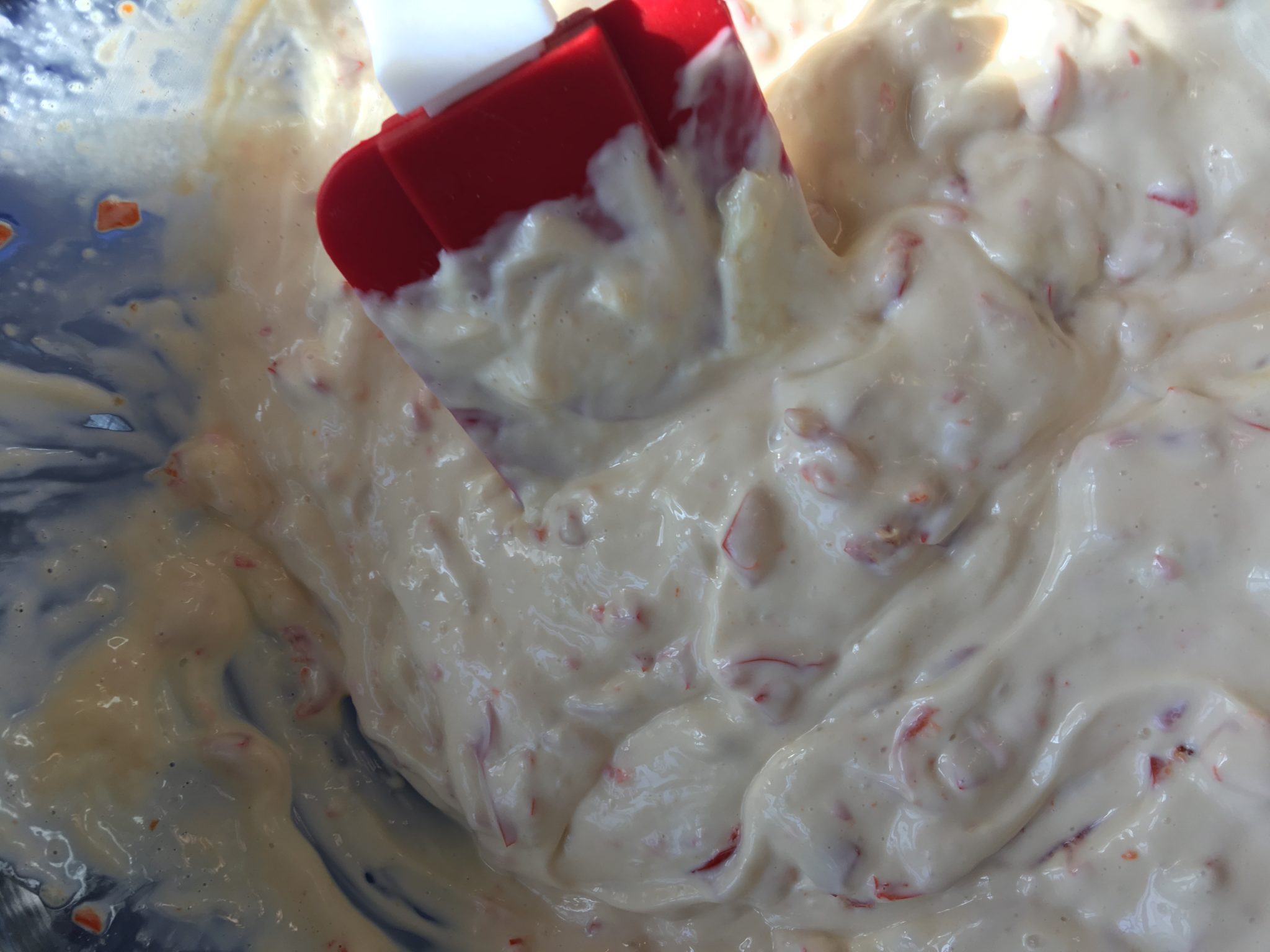 may and flavorings in a bowl with red spatula