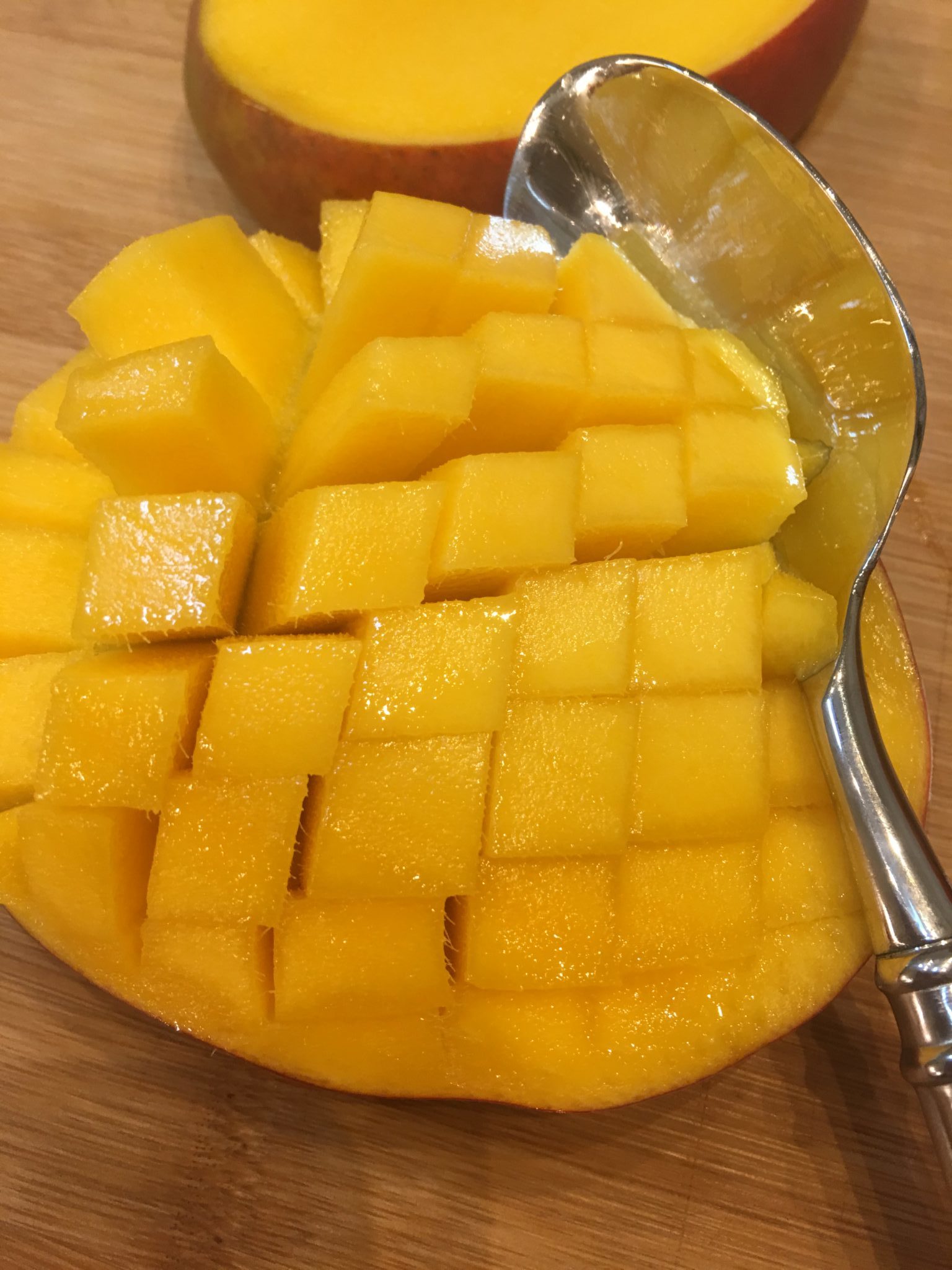 Use a spoon to get the meat from a mango