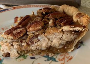 Showing the three layers of the layered pie: pecans, cheesecake and pecan pie filling