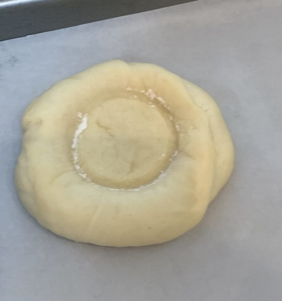 Showing a well in the center of the dough for a Feta Roll