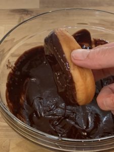 Dipping a donut in chocolate