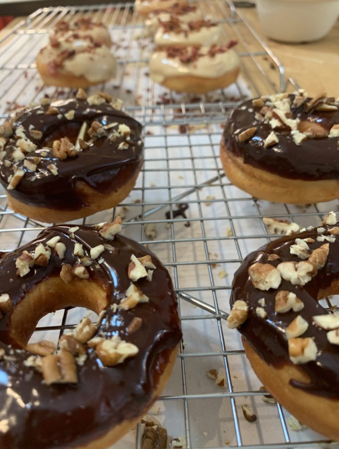 Chocolate Pecan donuts in front of Maple Glazed Bacon Donuts